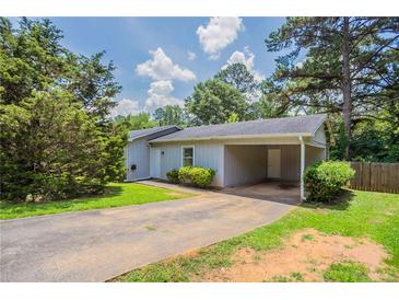 Charming single-story home with a covered carport, lush landscaping and well-manicured lawn at 502 Snowfall Ter, Palmetto, GA 30268