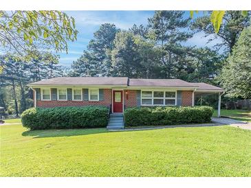 Charming brick home with a manicured front lawn and a red front door at 573 Allgood Rd, Stone Mountain, GA 30083
