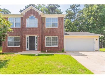 Charming brick two-story home with a well-manicured lawn and attached two-car garage at 5867 Heritage Walk, Lithonia, GA 30058