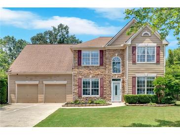 Attractive two-story home with stone accents, a well-kept lawn, and a two-car garage at 1002 Hallman Sw Ter, Marietta, GA 30064