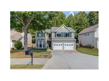 Charming home showcasing a well-maintained lawn, mature tree, and a convenient two-car garage at 3485 Parkbrooke Ln, Duluth, GA 30096
