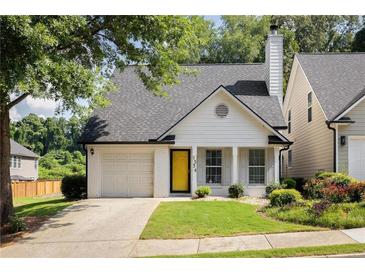 Charming single-Gathering home with a yellow door, a well-manicured lawn, and an attached one-car garage at 1334 Gates Se Dr, Atlanta, GA 30316
