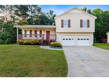 Charming two-story home with vinyl siding, a front porch, attached two-car garage, and a well-manicured front lawn at 421 River Trace Dr, Villa Rica, GA 30180