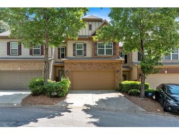 Charming townhome showcasing a two-car garage, stone accents, and well-maintained landscaping at 4349 Kousa Rd # 4, Austell, GA 30106
