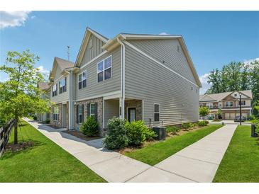 Charming townhouse with well-maintained lawn and sidewalk in a residential neighborhood at 6761 Cedar Glen Rd, Peachtree Corners, GA 30360