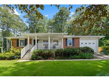 Charming brick home with a covered porch and lush landscaping providing great curb appeal at 1959 Audubon Ne Dr, Atlanta, GA 30329