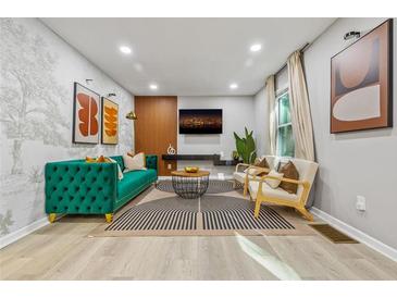 Modern living room with stylish decor, a plush green sofa, and eye-catching abstract artwork at 3408 Phillips Cir, Decatur, GA 30032