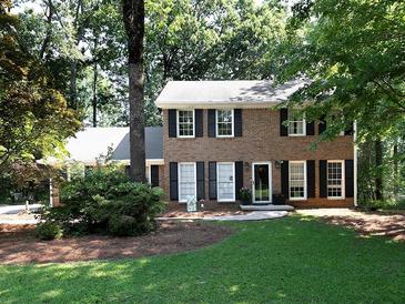 Charming two-story brick home with black shutters and a lush green lawn surrounded by mature trees at 21 Queen Anne Se Dr, Mableton, GA 30126