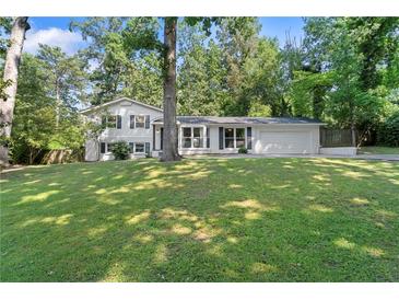 Charming home featuring a well-manicured front yard and a classic exterior with black shutters at 431 Hickory Se Ln, Smyrna, GA 30082