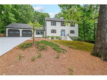Charming two-story home featuring a two-car garage, blue front door and well-maintained landscaping at 9805 Buice Rd, Alpharetta, GA 30022
