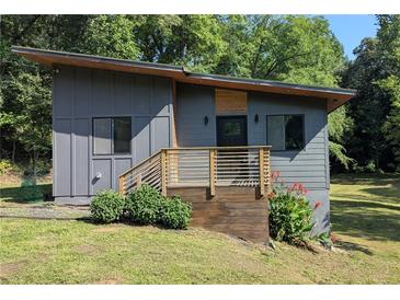 Striking modern home featuring sleek gray siding, wooden accents, and a beautifully landscaped entrance at 1092 Hillcrest Se Dr, Atlanta, GA 30316