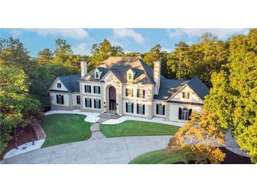 Stunning two-story home with a manicured lawn, elegant architectural details, and a circular driveway at 1806 Wynthrop Manor Sw Dr, Marietta, GA 30064