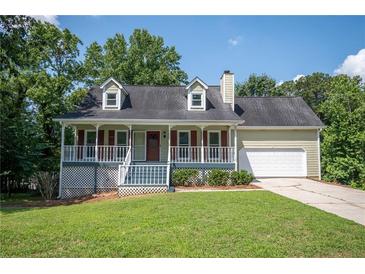 Charming home featuring a quaint front porch, well-maintained lawn, and attached two-car garage at 3381 Birchwood Trl, Snellville, GA 30078