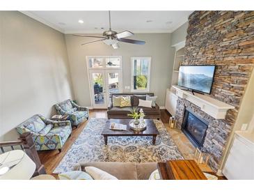 Bright living room with stone fireplace, high ceilings, ceiling fan, and plush seating arrangement at 255 Southerland Ne Ter # 207, Atlanta, GA 30307
