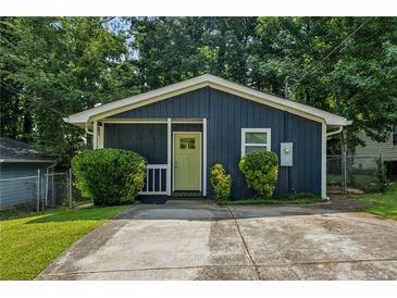 Charming, renovated home with a vibrant yellow door and well-maintained front yard at 1696 Thomas St, Decatur, GA 30032