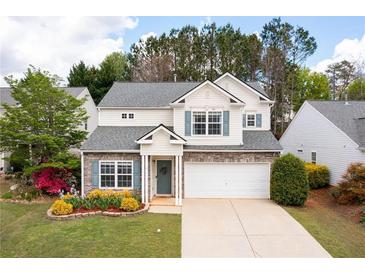 Charming two-story home featuring stone accents, a well-manicured lawn, and an attached two-car garage at 245 Weatherstone Pointe Dr, Woodstock, GA 30188
