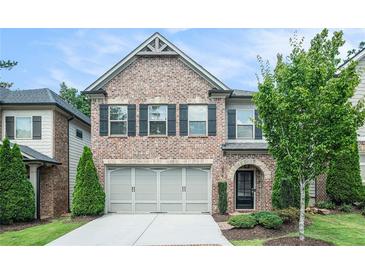 Two-story brick home featuring a two-car garage and well-maintained landscaping at 1878 Weston Ln, Tucker, GA 30084