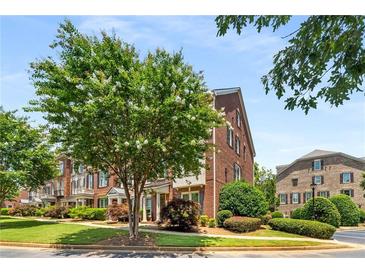 Attractive brick townhome with flowering tree and manicured landscaping at 11271 Calypso Dr, Alpharetta, GA 30009