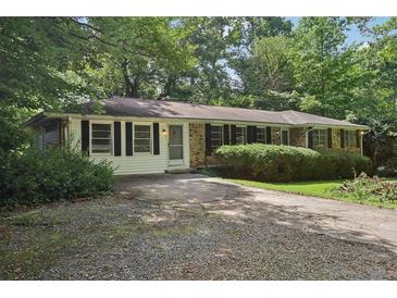 Charming single-story home with a mature trees, a driveway, and shuttered windows at 1194 Robert Ln, Marietta, GA 30062