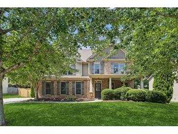 Charming two-story home with brick and siding, well-manicured lawn, and mature trees at 558 Grand Ivey Pl, Dacula, GA 30019