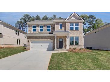 Charming two-story brick home with a well-maintained front lawn and an attached two-car garage at 623 Leafy Branch Way, Mcdonough, GA 30253