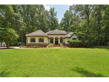 Beautiful single-story home boasts lush lawn, mature trees, and inviting curb appeal at 105 Postwood Dr, Fayetteville, GA 30215