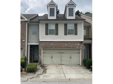 Charming two-story townhouse featuring a two-car garage and dormer windows at 5671 Radford Loop, Fairburn, GA 30213