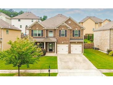 Charming two-story brick home with a well-manicured lawn and two-car garage, perfect for a growing Gathering at 3869 Maiden Fern Ln, Snellville, GA 30039