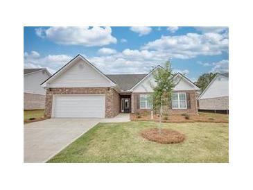 Charming single-story home with brick facade, attached garage, and well-manicured lawn at 670 Park Place Way, Social Circle, GA 30025