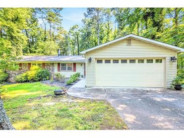Charming home with a two-car garage and well-maintained landscaping, nestled among mature trees at 1445 Woodhill Dr, Marietta, GA 30066