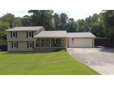 Charming two-story home featuring a manicured lawn, covered porch, two-car garage and American flag waving proudly at 2081 Old Peachtree Road Northeast Rd, Lawrenceville, GA 30043