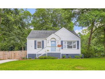 Charming brick home featuring a well-manicured lawn, blue shutters, and a cozy front porch, nestled among mature trees at 512 Allendale Dr, Decatur, GA 30032