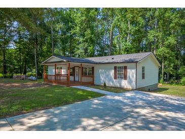 Charming single story home featuring a large yard and lovely covered front porch perfect for relaxing at 995 Highway 101 S, Temple, GA 30179