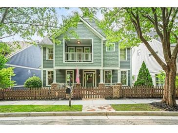 Charming two-story home with a welcoming front porch, fenced yard, and mature trees at 1622 Gates Nw Pl, Atlanta, GA 30318