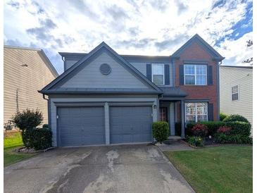 Charming two-story home with a two-car garage, manicured lawn, and tasteful brick and siding combination at 640 Dahoma Trl, Woodstock, GA 30188