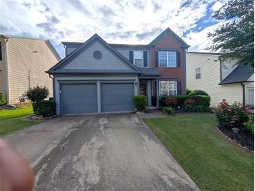 Charming two-story home with a well-manicured lawn and a two-car garage in a suburban neighborhood at 640 Dahoma Trl, Woodstock, GA 30188