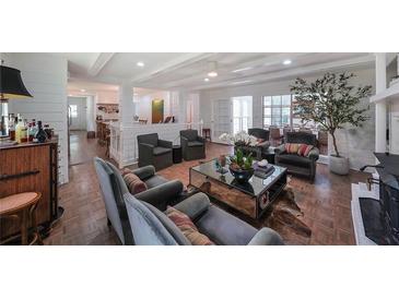 Cozy living room featuring a brick fireplace, hardwood floors, and comfortable seating arrangements with natural lighting at 167 Garden Ln, Decatur, GA 30030