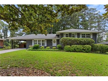 Charming home with a well-maintained front yard and a welcoming entrance with covered parking at 2416 Elmwood Se Cir, Atlanta, GA 30339