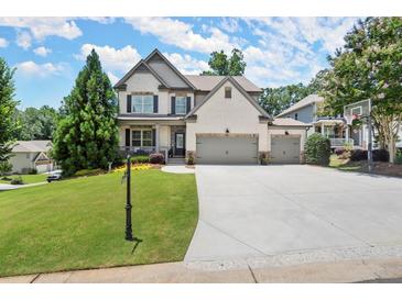 Charming two-story home with a well-manicured lawn, a driveway, and a basketball hoop near the garage at 5605 Miners Rdg, Cumming, GA 30028