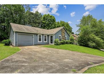 Charming single-story home featuring a stone accent wall, attached garage, and well-maintained front lawn at 1050 Chapman Circle Cir, Stone Mountain, GA 30088