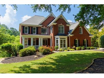 Charming two-story red brick home featuring a landscaped yard and welcoming front porch at 130 Hamilton Way, Roswell, GA 30075