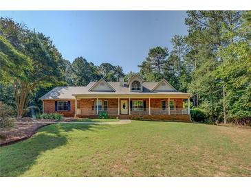 Charming brick home featuring a welcoming front porch and well-manicured lawn at 502 Brookline Pl, Mcdonough, GA 30252
