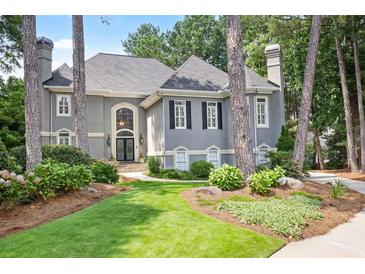 Charming two-story home boasts a landscaped front yard, mature trees, and a welcoming entrance at 1111 Waterford Green Pt, Marietta, GA 30068