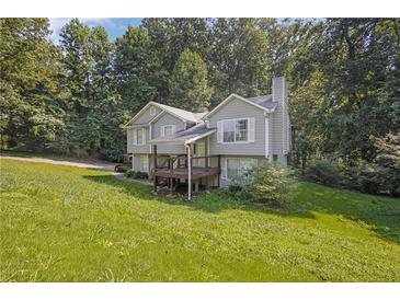 Inviting two-story home with a gray exterior, charming front porch, and a lush green lawn at 3860 Paint Cir, Douglasville, GA 30135
