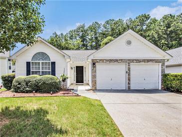 Charming single Gathering home boasts a two car garage, neutral paint, and manicured lawn at 3198 Liberty Commons Dr, Kennesaw, GA 30144