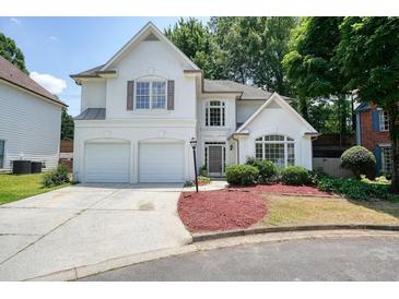 Charming stucco home with a two-car garage, manicured lawn, and inviting curb appeal at 1971 Wellesley Trce, Dunwoody, GA 30338