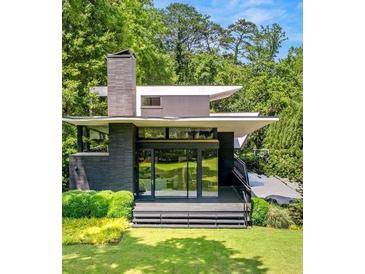 Stunning modern home surrounded by lush greenery with sleek lines and expansive windows at 3891 Wieuca Rd, Atlanta, GA 30342