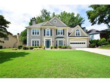 Charming two-story home features a well-manicured lawn and attached two car garage at 340 Channings Lake Dr, Lawrenceville, GA 30043