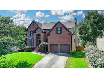 Charming brick two-story home with two-car garage and well-manicured front lawn at 350 River Walk Ter, Johns Creek, GA 30024
