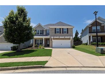 Charming two-story home with a well-manicured lawn, two-car garage, and classic brick facade at 320 Pebblestone Ln, Canton, GA 30115